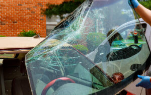 Shattered windshield being removed from a vehicle